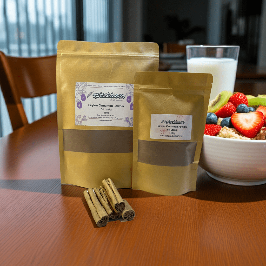 SpiceBloom Ceylon cinnamon powder packets on a breakfast table beside a bowl of oats, fresh fruit, and a glass of milk or smoothie in natural daylight.